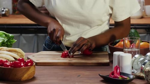 Woman Slicing Red Pepper in Bright Kitchen