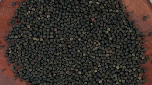 Overhead Shot of Black Peppercorns on Wood