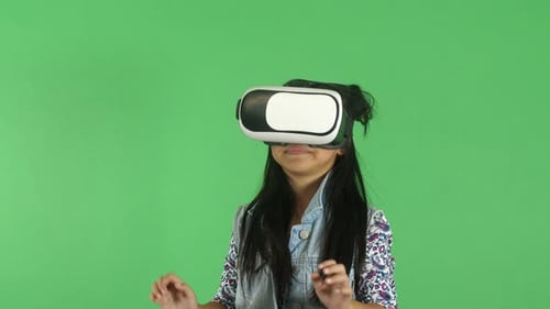 Child Wearing VR Headset Interacts with Virtual World