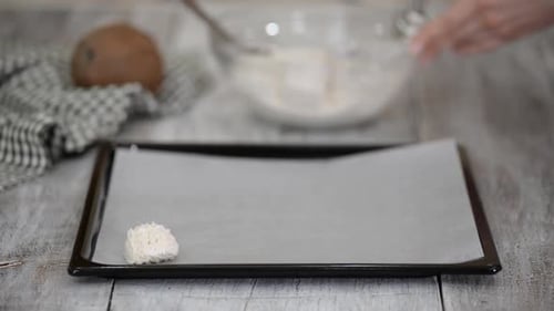 Mujer preparando galletas en la cocina haciendo macarrones de coco