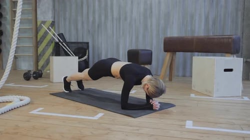 Young Adult Woman Doing Forearm Plank in Gym