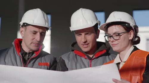Construction Workers Reviewing Building Plans Together