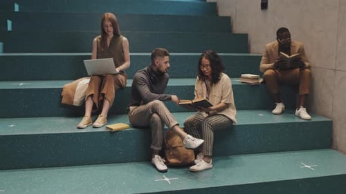 Des étudiants universitaires multiethniques étudient dans les escaliers
