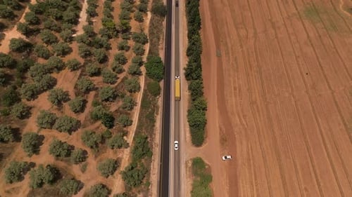 Truck loaded with Shipping Container driving on a rural highway, Aerial follow footage.