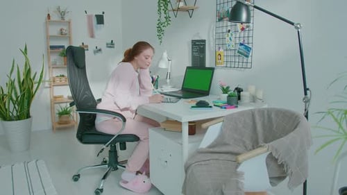 Woman Works at Desk with Green Screen Laptop