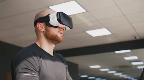 Young Strong Man Exercising on Treadmill at the Gym Wearing VR Glasses Slow Motion Close Up