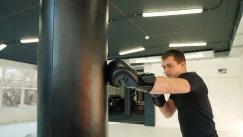 MMA Fighter Boxers Doing Some Training on a Punching Bag at a Gym Close Up Power Punch Kicks Macro