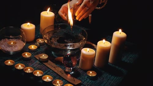 Candles and Crystal Ball on Table in Darkness