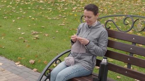Knitting in autumn park.