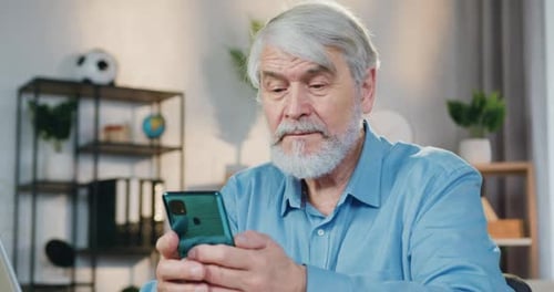 Senior Man Using Cell Phone Indoors