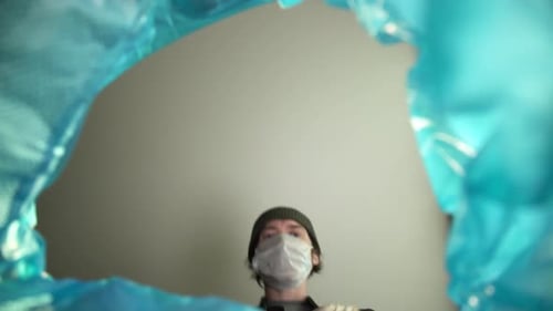 End of Quarantine Victory Over the Coronavirus. View From the Trash Can a Man Removes a Medical Mask