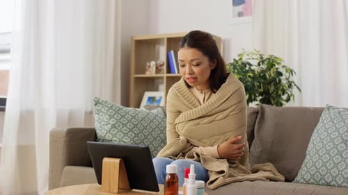 Sick Woman Talking to Tablet on Couch