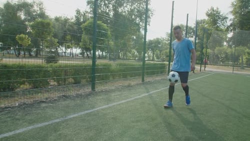 Young Man Juggling Soccer Ball in City Park