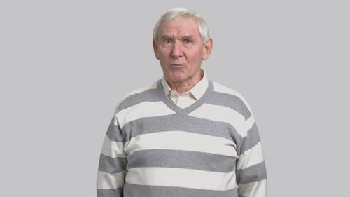 Senior Man Gesturing and Talking to Camera