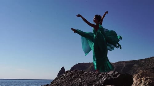 Side View a Young Beautiful Sensual Woman with Black Hair in a Long Mint Dress Posing on a Beach