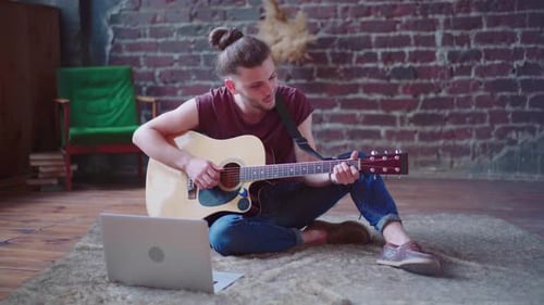 Man Playing Acoustic Guitar in Urban Loft