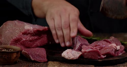 Butcher Cutting Raw Red Meat with Cleaver