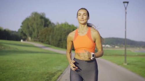 Fit Woman Jogging in Sunny Green Park