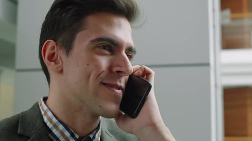 Young Man Talking on Cellphone in Office