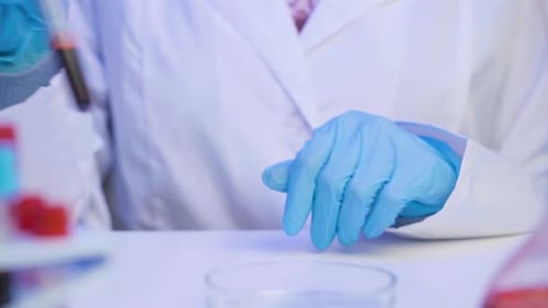 Scientist Woman Hands in Gloves Holding a Tube with Blood Sample Close Up