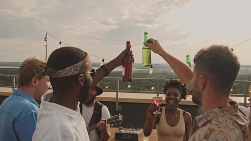 Friends Celebrate on Rooftop with Drinks and Guitar