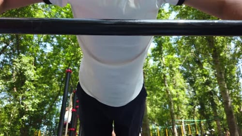 Man Doing Pull-Ups in Park During Daytime