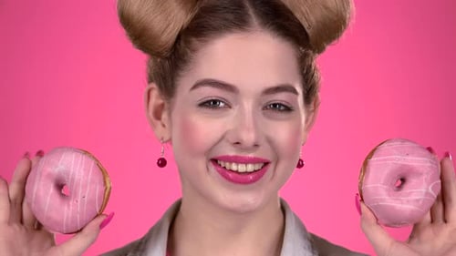 Teenager Sniffs the Cake and Smile. Pink Background. Close Up. Slow Motion