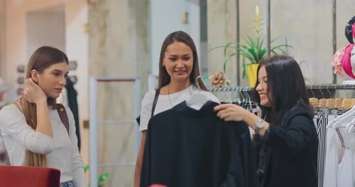 Lindas garotas escolhem roupas em uma boutique