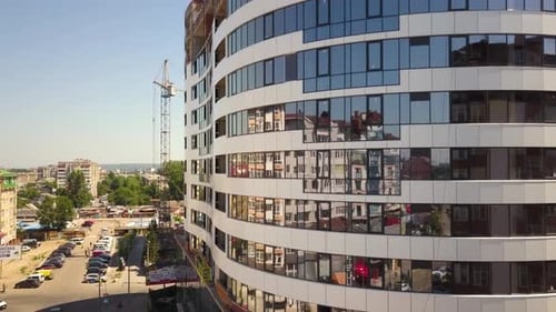 Luftaufnahme des Betonrahmens eines im Bau befindlichen Hochglaswohnhauses in einer Stadt.