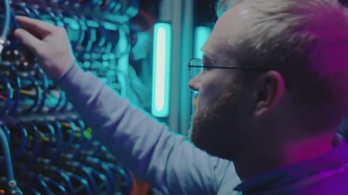 IT Professional Inspecting Wires in Data Server Room