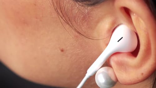 Earbud Being Inserted Into Ear Close Up