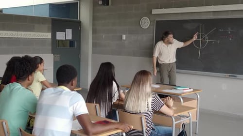 Teacher Explains Math to Students in Classroom