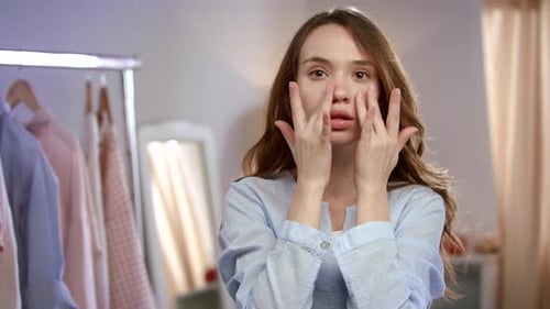 Young Woman Face Skin Care. Close Up of Pretty Girl Touching Face with Lotion
