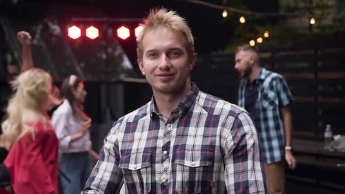 Smiling Man Poses at a Nighttime Party
