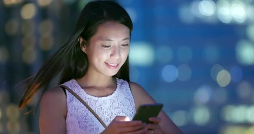 Woman using smart phone at night