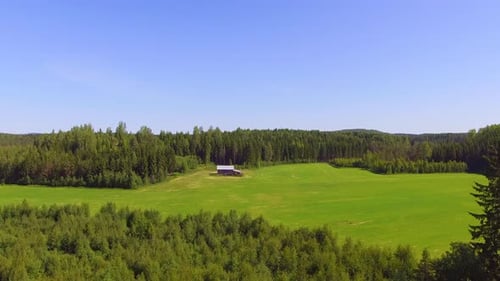 Luftbild einer einsamen Scheune in der finnischen Landschaft inmitten des Waldes. Langsam