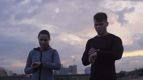 Couple Checking Smartwatches Before a Morning Run