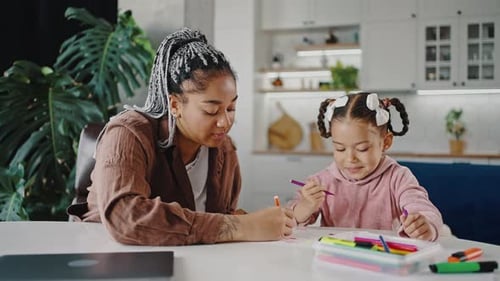 Young Cute African American Little Girl Drawing with Her Mother Spending Happy Time Together at Home