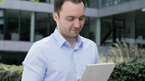 Man Using Tablet Outdoors in Urban Setting