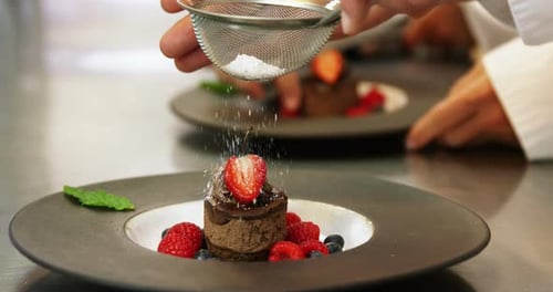 Chef Sprinkles Sugar on Elegant Chocolate Berry Dessert