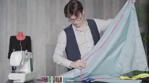 Middle Shot of Confident Professional Tailor Measuring Cloth with Tape in Atelier