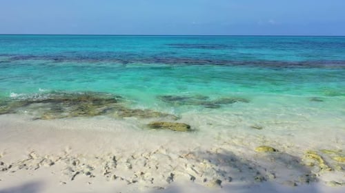 Wide angle fly over abstract shot of a sandy white paradise beach and blue water background in high