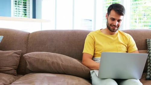 Young Man Working on Laptop on Couch