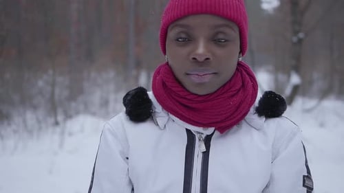 Portrait of African American Girl Standing in Winter Forest Looking in Camera Close Up