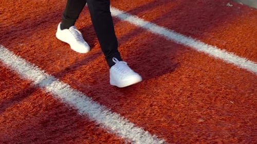 Legs Walking on a Red Urban Running Track