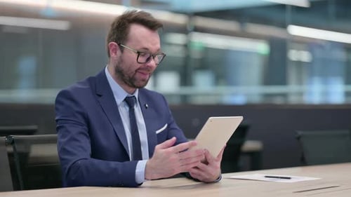 Businessman Video Calling With Tablet in Modern Office