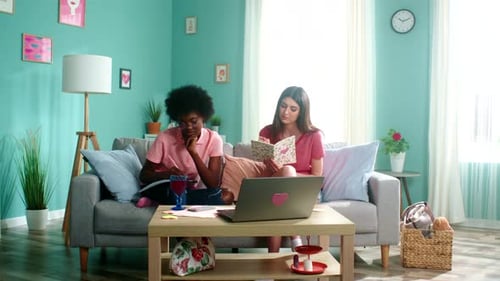 Two Young Adults Studying Together on Couch