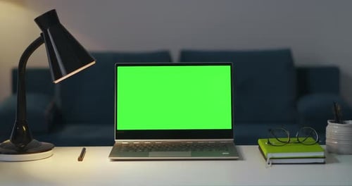Zooming Shot of Working Place in Apartment Notebook with Green Screen Lamp and Books for Remote Work