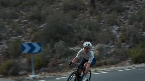 Young Professional Female Cyclist on Curve Road