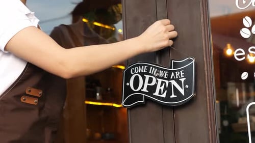Woman Opening a Store Front Door